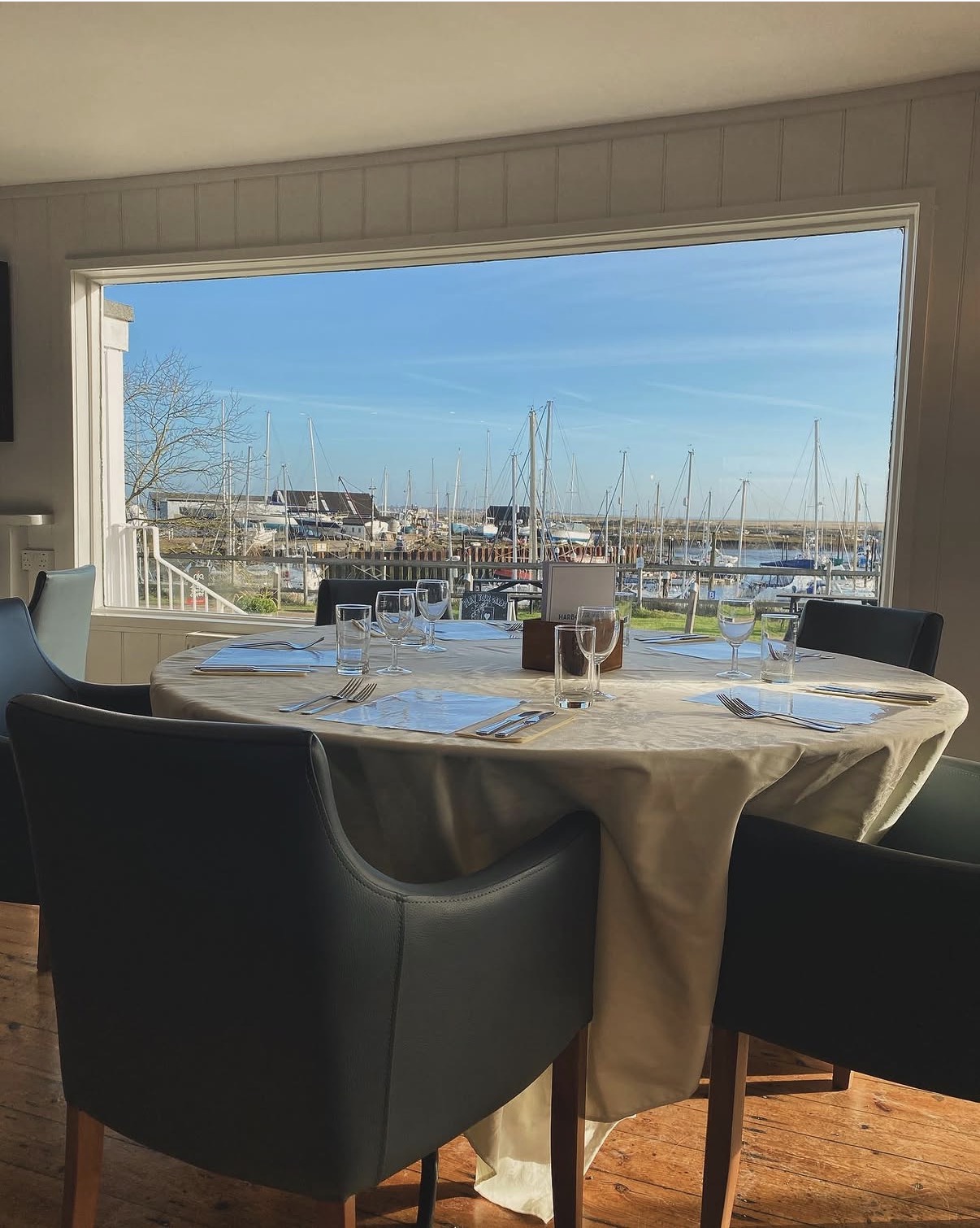 A table set beside the window overlooking Tollesbury Marina