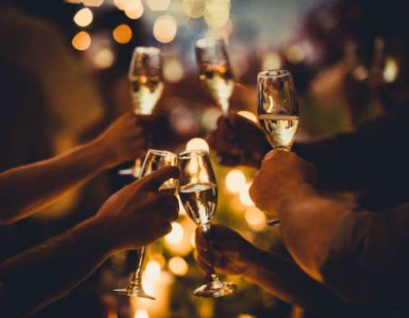 Numerous hands holding champagne flutes with champagne celebratory toast silhouettes